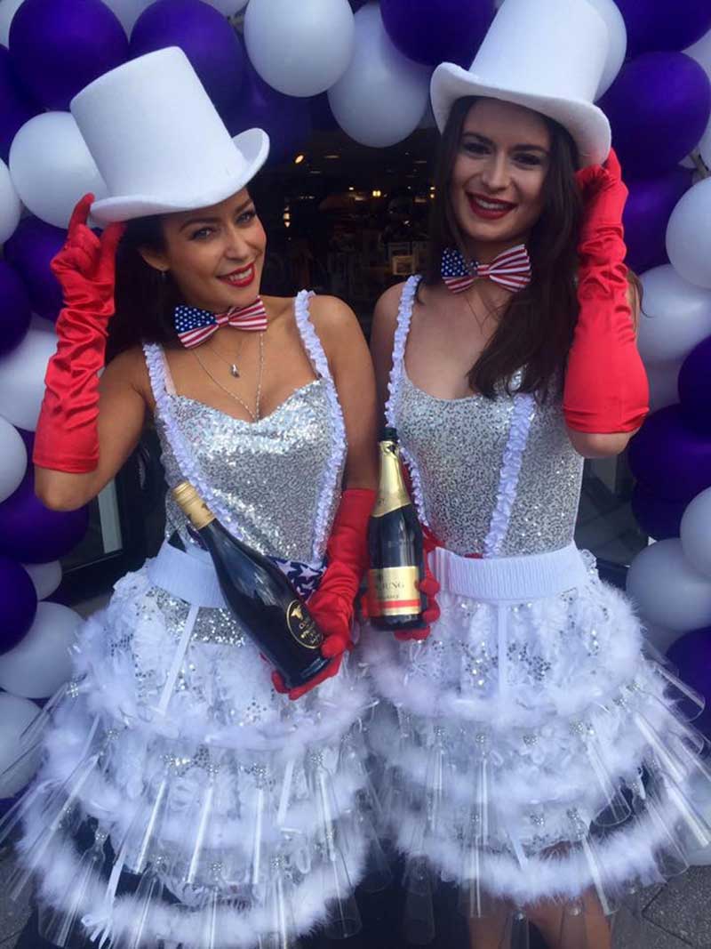 Champagneduo met witte hoge hoeden en feestelijke outfits